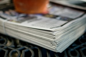 Newspaper stack to signify the times we applied for jobs circling listings and scheduling appointments via payphone. 